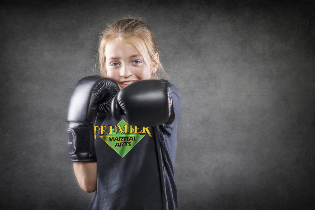 Happy and confident young girl practicing martial arts