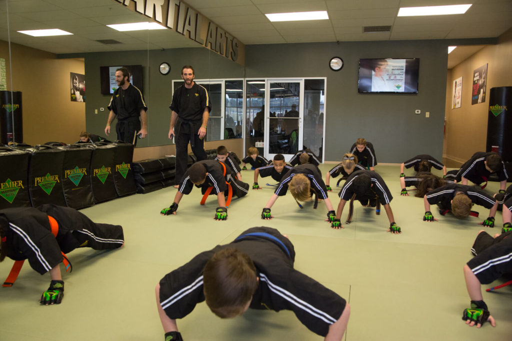 Kids in martial arts class doing pushups to build fitness and strength